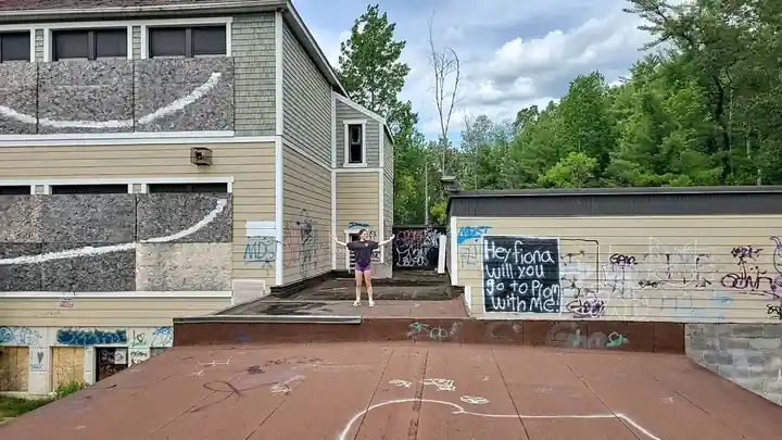 Une personne pose dans une cour couverte de graffitis.